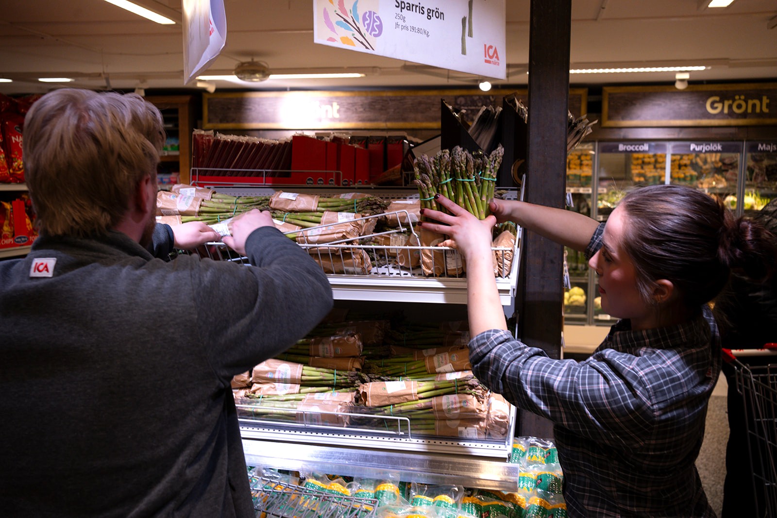 Colleagues restocking the vegetable section